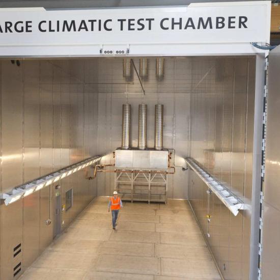 Vue intérieure de la grande chambre d'essais climatiques de Sirris dans le cadre du laboratoire de R&D Harsh, avec un homme pour illustrer la taille de la chambre