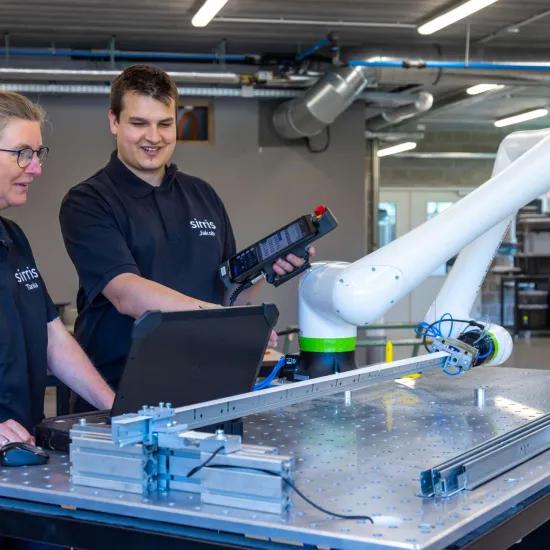 Deux ingénieurs de Sirris testant et instruisant le cobot