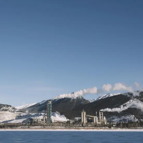 Factory in Norway next to river and snowy mountains