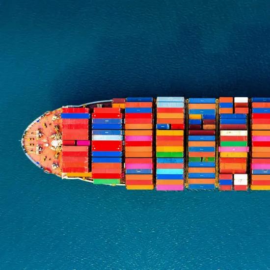 Bird view of a freighter with colourful containers referring to the business crisis due to the blocking of the Suez Canal by the container ship Ever Given and representing business resilience trough circular collaboration.