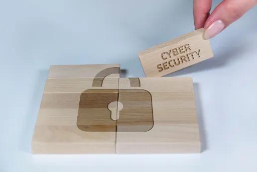 A wooden puzzle with a padlock symbol engraved on its pieces, symbolizing cybersecurity in wood production. One piece labeled "CYBER SECURITY" is being placed to complete the puzzle.