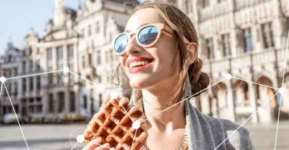 Woman smiling and eating a Belgian waffle on Brussels central square