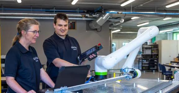 Deux ingénieurs de Sirris testant et instruisant le cobot