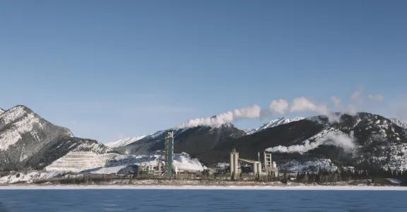 Usine en Norvège près d'une rivière et de montagnes enneigées