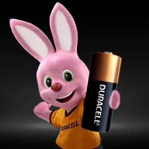 Smiling pink Duracell bunny - mascotte of the Duracell batterie brand - wearing an orange Duracell t-shirt and holding up big duracell battery. Duracell is one of the winners of the Factory of the Future Awards 2025.