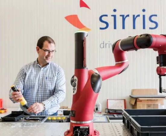 Sirris expert working besides a collaborative industrial robot (cobot) in lab