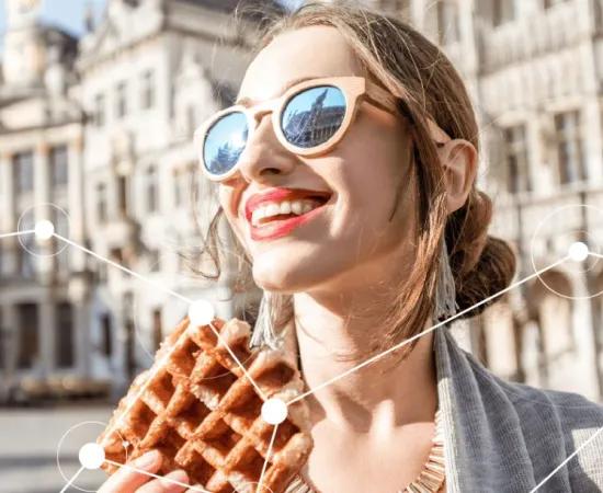 Woman smiling and eating a Belgian waffle on Brussels central square