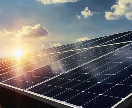 Solar panels under a blue sky and rising sun