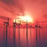 Offshore wind mills against sunset