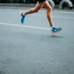 Runner with bare legs and clear blue running shoes running on asfalt road illustrating motion analysis of foot plantar pressure in running exercises