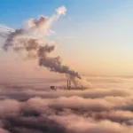 View of a thermal energy installation in the distance above the clouds, columns of steam